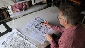 Gilles Calza travaille sur une page de l'album 6.